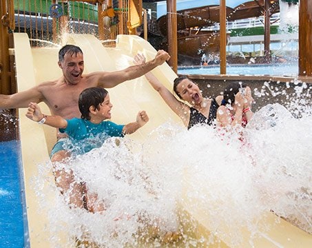 Family enjoying a water slide splash on a cruise ship | MSC Cruises Family enjoying a water slide splash on a cruise ship | MSC Cruises