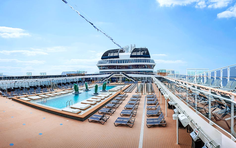 A luxurious pool deck with sun loungers on an MSC cruise ship under a clear blue sky | MSC Cruises